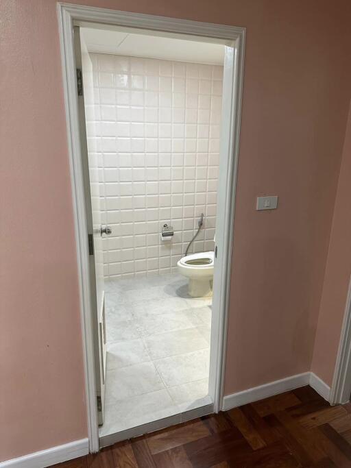 Bathroom with white tiled walls and toilet