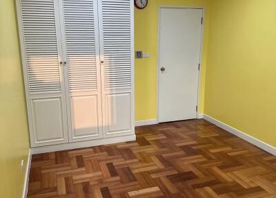 Empty bedroom with wooden floor and white closet