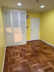 Empty bedroom with wooden floor and white closet