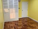 Empty bedroom with wooden floor and white closet