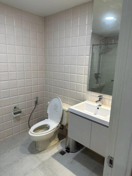 Modern bathroom with square tiles, toilet, and sink