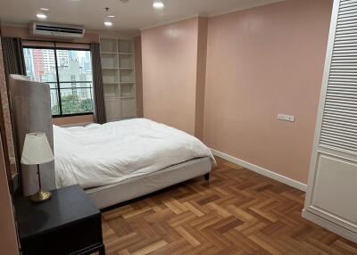 Bedroom with large window and hardwood flooring