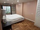 Bedroom with large window and hardwood flooring