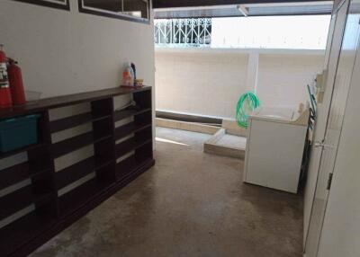 Spacious laundry area with storage shelves and washing machine