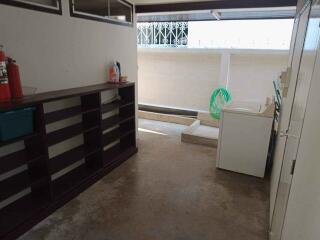 Spacious laundry area with storage shelves and washing machine