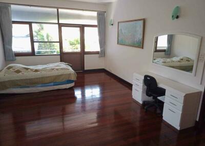 Spacious bedroom with large windows and wooden flooring