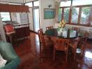 Dining room with a round table and six chairs, adjacent to a kitchen