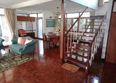 Spacious and well-lit living area featuring a dining table and a staircase