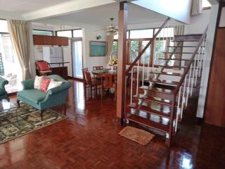 Spacious and well-lit living area featuring a dining table and a staircase