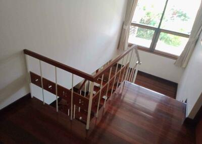 Indoor staircase with wooden steps and a window providing natural light.