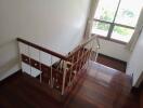 Indoor staircase with wooden steps and a window providing natural light.