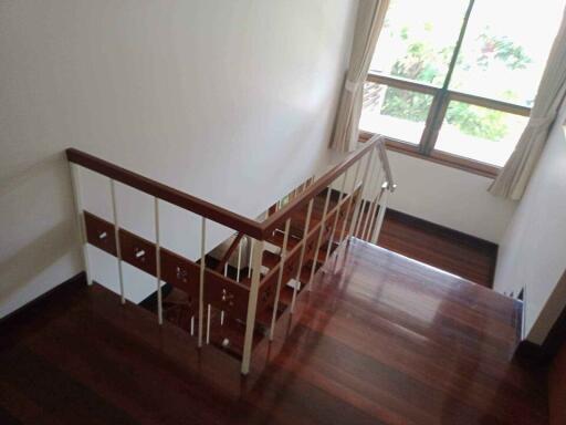 Indoor staircase with wooden steps and a window providing natural light.