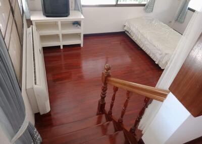 Bedroom with wooden floor and basic furnishings