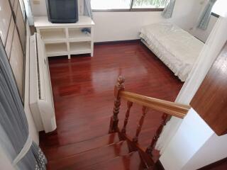 Bedroom with wooden floor and basic furnishings