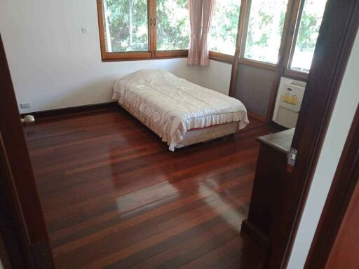 Bright bedroom with wooden floors and large windows