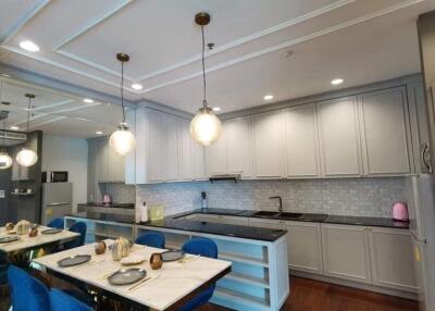 Modern kitchen with dining area, white cabinets, and stainless steel appliances