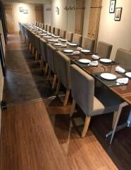 Long dining table with multiple chairs in a well-lit room