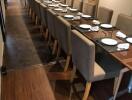 Long dining table with multiple chairs in a well-lit room