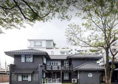 Front view of a two-story gray house with a lawn and trees