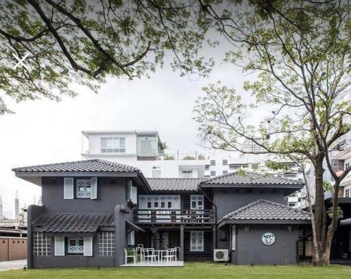 Front view of a two-story gray house with a lawn and trees