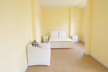 Spacious bedroom with bed, nightstands, and chair