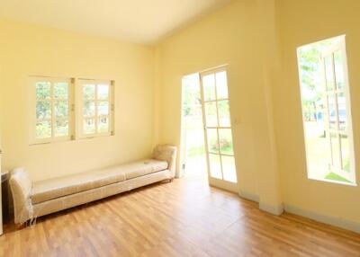 Well-lit living room with large windows and door to outside