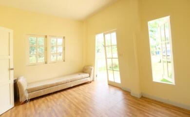 Well-lit living room with large windows and door to outside