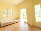 Well-lit living room with large windows and door to outside