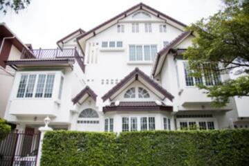 Front exterior view of a multi-story house with large windows and greenery