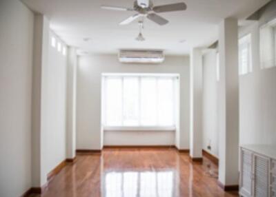 Empty living room with large window and ceiling fan