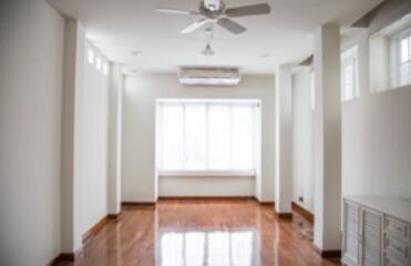 Empty living room with large window and ceiling fan