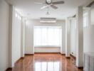 Empty living room with large window and ceiling fan