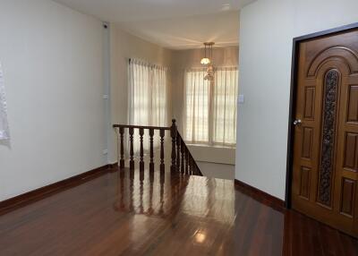 Spacious, well-lit living area with wooden flooring and staircase