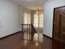 Spacious, well-lit living area with wooden flooring and staircase