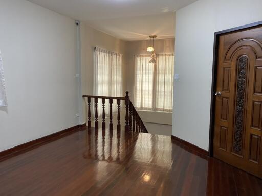 Spacious, well-lit living area with wooden flooring and staircase