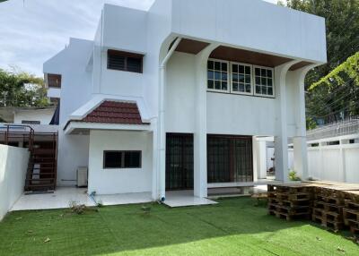 Exterior view of a white two-story house with a lawn