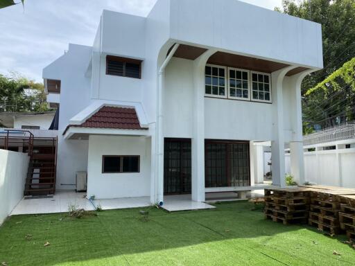 Exterior view of a white two-story house with a lawn