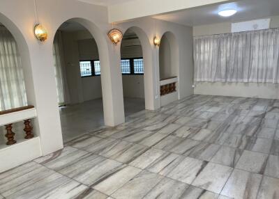 Spacious living room with marble flooring and arched doorways