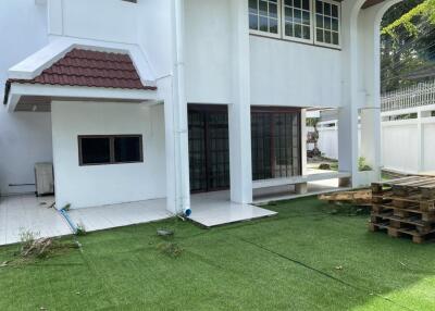 Backyard area with tiled patio and artificial grass