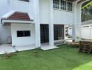 Backyard area with tiled patio and artificial grass