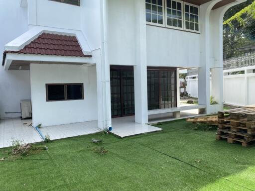 Backyard area with tiled patio and artificial grass