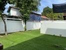 Backyard with green lawn and trees