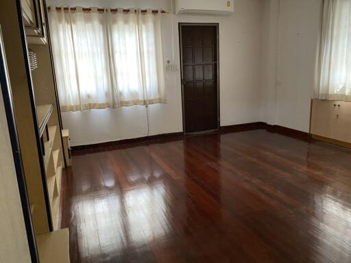 A spacious, unfurnished living room with wooden floors.