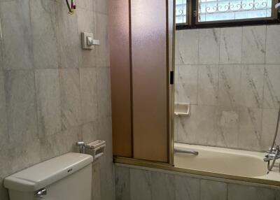 Marble-tiled bathroom with shower and toilet