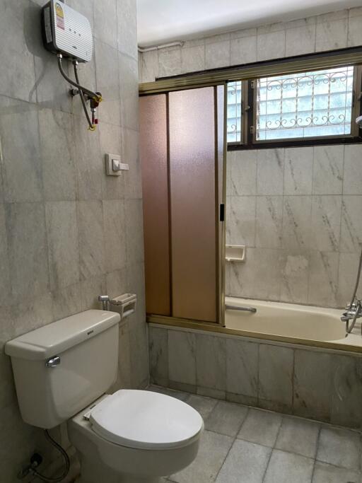 Marble-tiled bathroom with shower and toilet