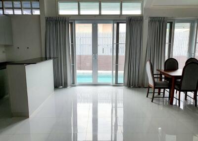 Bright living and dining area with large windows and pool view