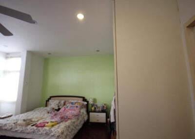 Bedroom with green accent wall and white furnishings