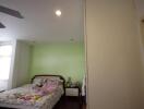 Bedroom with green accent wall and white furnishings