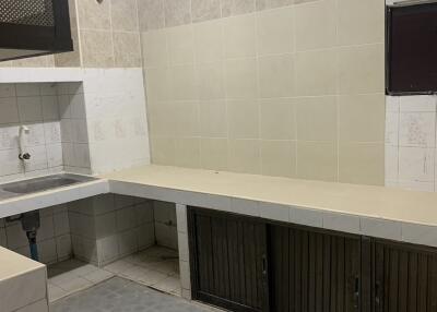 Basic kitchen with tiled walls, simple countertop, and single sink