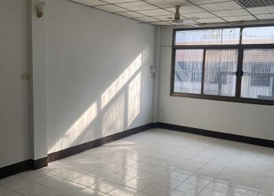 Spacious empty room with large windows, ceiling fan, and tiled floor